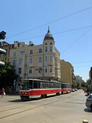 two red and white trolley cars in front of a building at 113 in Sofia with 2BR and 2 full bath in Sofia