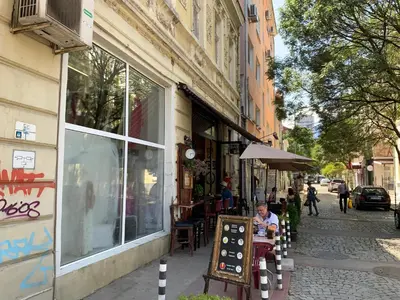 a man sitting at a table in front of a building at 113 in Sofia with 2BR and 2 full bath in Sofia