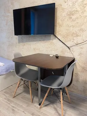 a desk with two chairs and a television on a wall at Colonel apartment 947 in Sofia