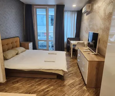 a bedroom with a bed and a desk with a television at Colonel apartment Diamond in Sofia