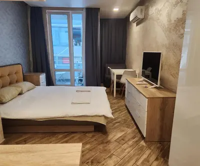 a bedroom with a bed and a desk with a television at Colonel apartment Diamond in Sofia