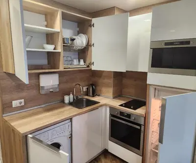 a small kitchen with white cabinets and a sink at Colonel apartment Diamond in Sofia