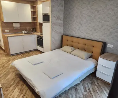 a large bed in a small room with a kitchen at Colonel apartment Diamond in Sofia