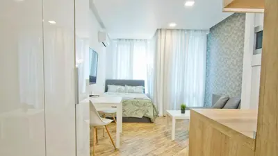 a bedroom with a bed and a table in a room at Colonel apartment Bijou in Sofia