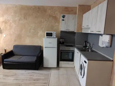 a kitchen with a black chair and a white refrigerator at Colonel apartment 957 in Sofia