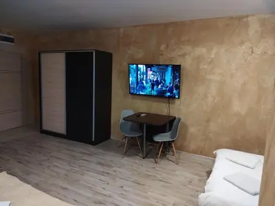 a living room with a table and a tv on the wall at Colonel apartment 957 in Sofia