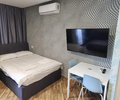 a small room with a bed and a table and a flat screen tv at Colonel apartment Relax in Sofia