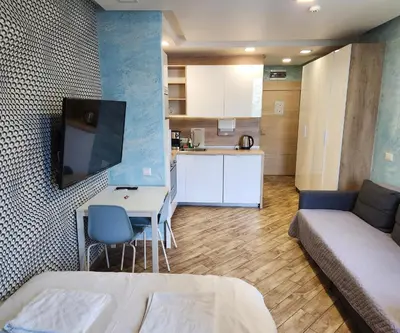 a living room with a couch and a table and a kitchen at Colonel apartment Relax in Sofia
