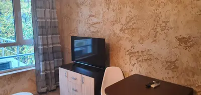 a living room with a table and a tv on a cabinet at Colonel apartment 954 in Sofia