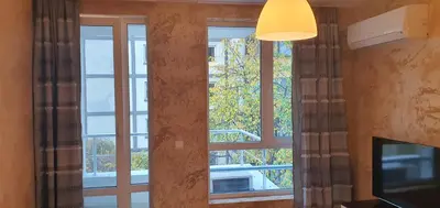 a room with a window with curtains and a television at Colonel apartment 954 in Sofia