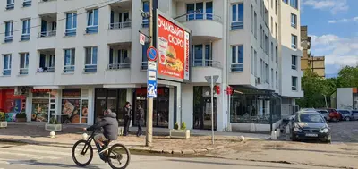 a person riding a bike down a street in front of a building at Colonel apartment 956 in Sofia