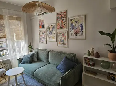 a living room with a green couch and pictures on the wall at S íRMA Apartment - The Soul of Central Sofia in Sofia