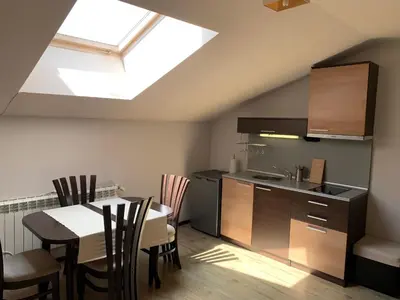 a kitchen and dining room with a table and a skylight at 7 apartments in Alexander complex in Bansko