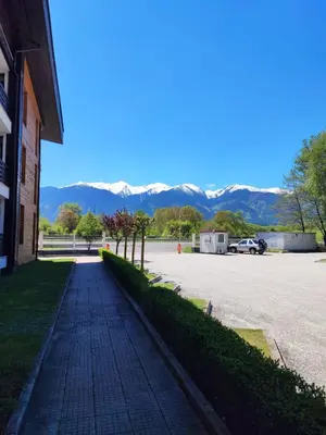 a cobblestone street next to a parking lot with mountains at Aspen Valley Studio Apartment Аспен Вали студио апартамент in Razlog