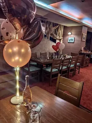 a dining room with a table with a wine glass and balloons at Spider House Aparthotel in Pamporovo