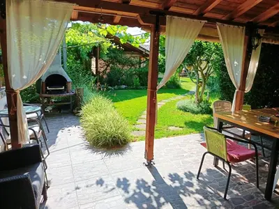 a patio with a fireplace and a table and chairs at Къща за гости Рупите , Guest House Relax Rupite in Rupite