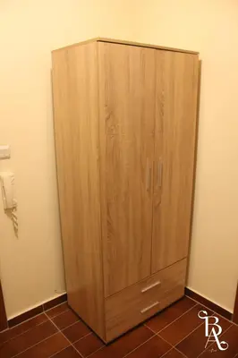 a wooden cabinet in the corner of a room at Bansko Apart in Bansko