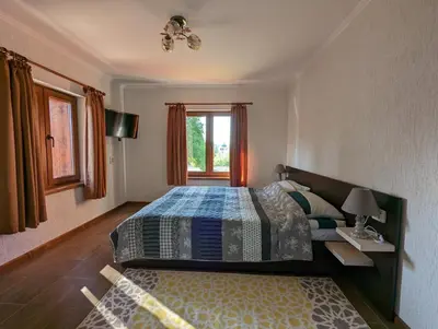 a bedroom with a large bed and a window at Къща за гости Феникс in Koprivshtitsa