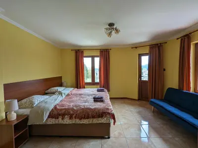 a bedroom with a bed and a blue couch at Къща за гости Феникс in Koprivshtitsa