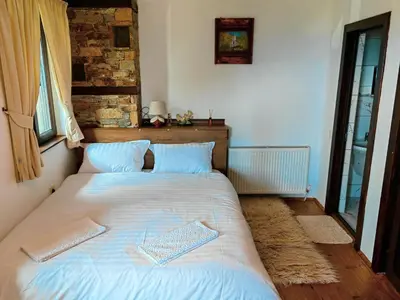 a bed in a bedroom with two books on it at Rimovata Kashta Guest House in Leshten