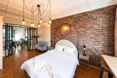 a bedroom with a brick wall and a white bed at Heart of the City Center Lux Apartment with View in Sofia