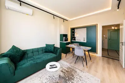 a living room with a green couch and a table at Heart of the City Center Lux Apartment2 with View in Sofia