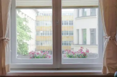 a window with two windows with flowers in a window sill at The Top Spot - Cute Little Studio in the Center by Flat Mаnager in Sofia