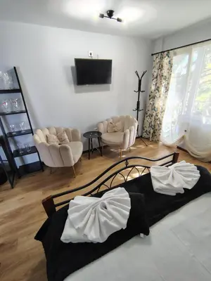 a living room with a bed and a tv at Стаи за гости - Цветето на Ангела in Bankya