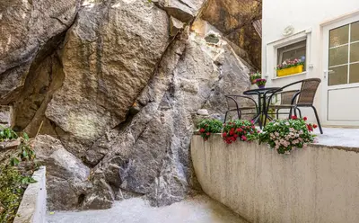 a table and chairs in front of a rock wall at The Old Town Vintage 2-Bedroom Jewel by Flat Mаnager in Plovdiv
