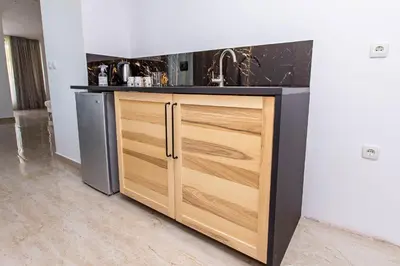a kitchen with a sink and a wooden cabinet at апартаменти Пасажио in Sandanski