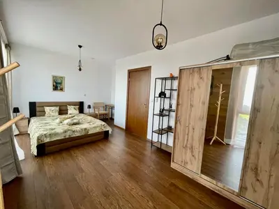 a bedroom with a bed and a wooden floor at Pirin Golf Penthouse Iliyana in Bansko
