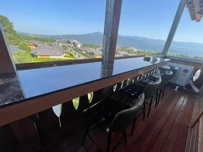 a bar with chairs on a balcony with a view at Pirin Golf Penthouse Iliyana in Bansko