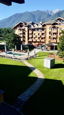 a view of a park with a building and a pool at Pirin Golf Penthouse Iliyana in Bansko