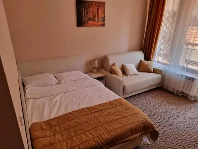 a bedroom with a bed and a couch and a window at Borovets Ski&Spa Studio - Semiramida Garden A16 in Borovets