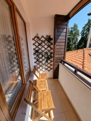 a balcony with two wooden chairs and a window at Borovets Ski&Spa Studio - Semiramida Garden A16 in Borovets