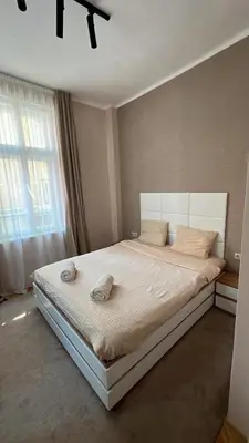 a bedroom with a large bed with a large window at Luxury Apart Vitosha Boulevard in Sofia