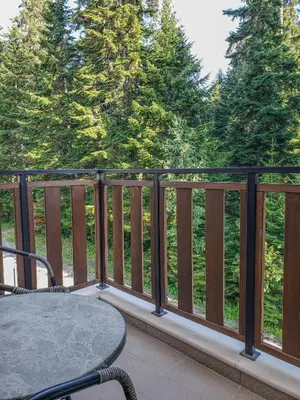 a balcony with a table and a view of trees at Lovely Borovets Apartment in Borovets