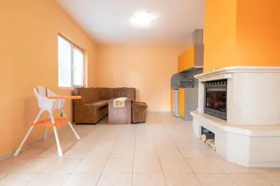 a living room with a couch and a fireplace at Вили Тихия Кът in Ribarica