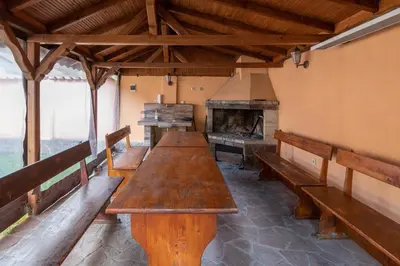 a row of wooden benches in a room with an oven at Вили Тихия Кът in Ribarica