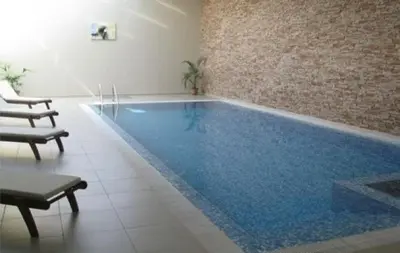 a large swimming pool in a building with a blue pool at Aspen Golf Resort Studio I205 in Bansko
