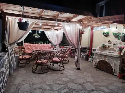 a patio with a table and chairs and a fireplace at Делоре in Sarnitsa