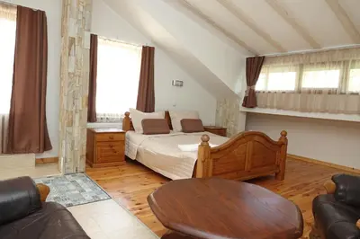 a bedroom with a bed and a table and a couch at Стаи за гости RADEA in Devin