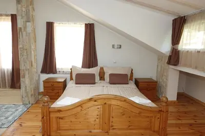 a bedroom with a wooden bed in a room at Стаи за гости RADEA in Devin