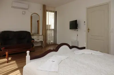 a bedroom with a bed and a couch and a mirror at Стаи за гости RADEA in Devin