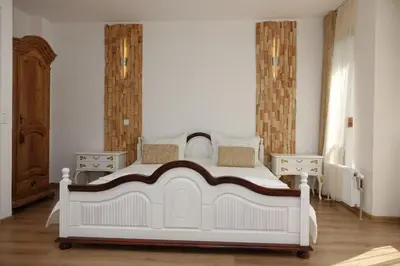 a bedroom with a white bed and two night stands at Стаи за гости RADEA in Devin