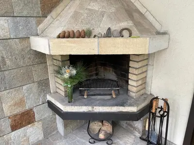 a stone fireplace with a vase of flowers on it at Вила 11 - семейна почивка в сърцето на Балкана in Ribarica