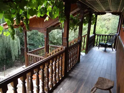 a porch of a cabin with a bench on it at Недкова къща in Koprivshtitsa