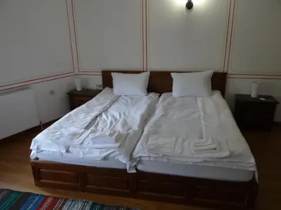 a bedroom with a bed with white sheets and pillows at Недкова къща in Koprivshtitsa