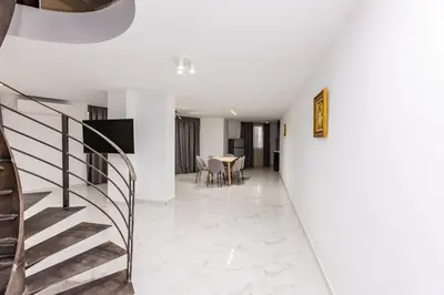 a staircase leading to a dining room with a table at Мезонет Пасажио in Sandanski