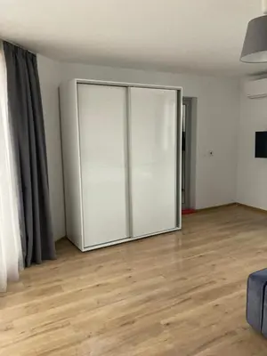 a large sliding door in a room with a wooden floor at Мезонет Пасажио in Sandanski